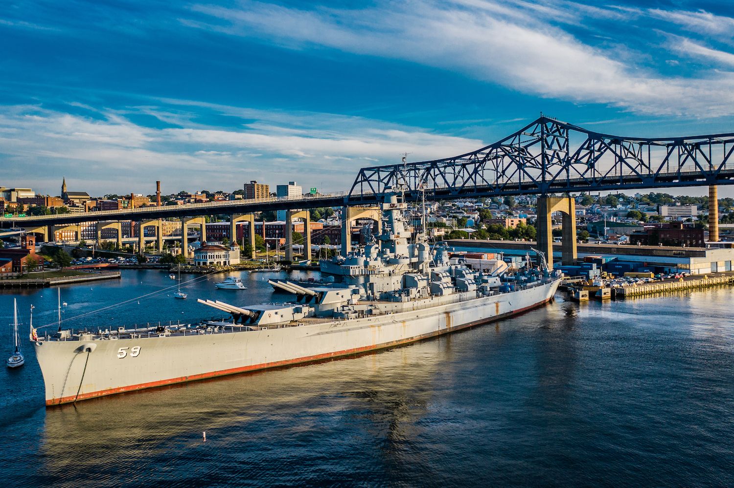 Image of fall river in Massachusetts with a bridge and boats in the background